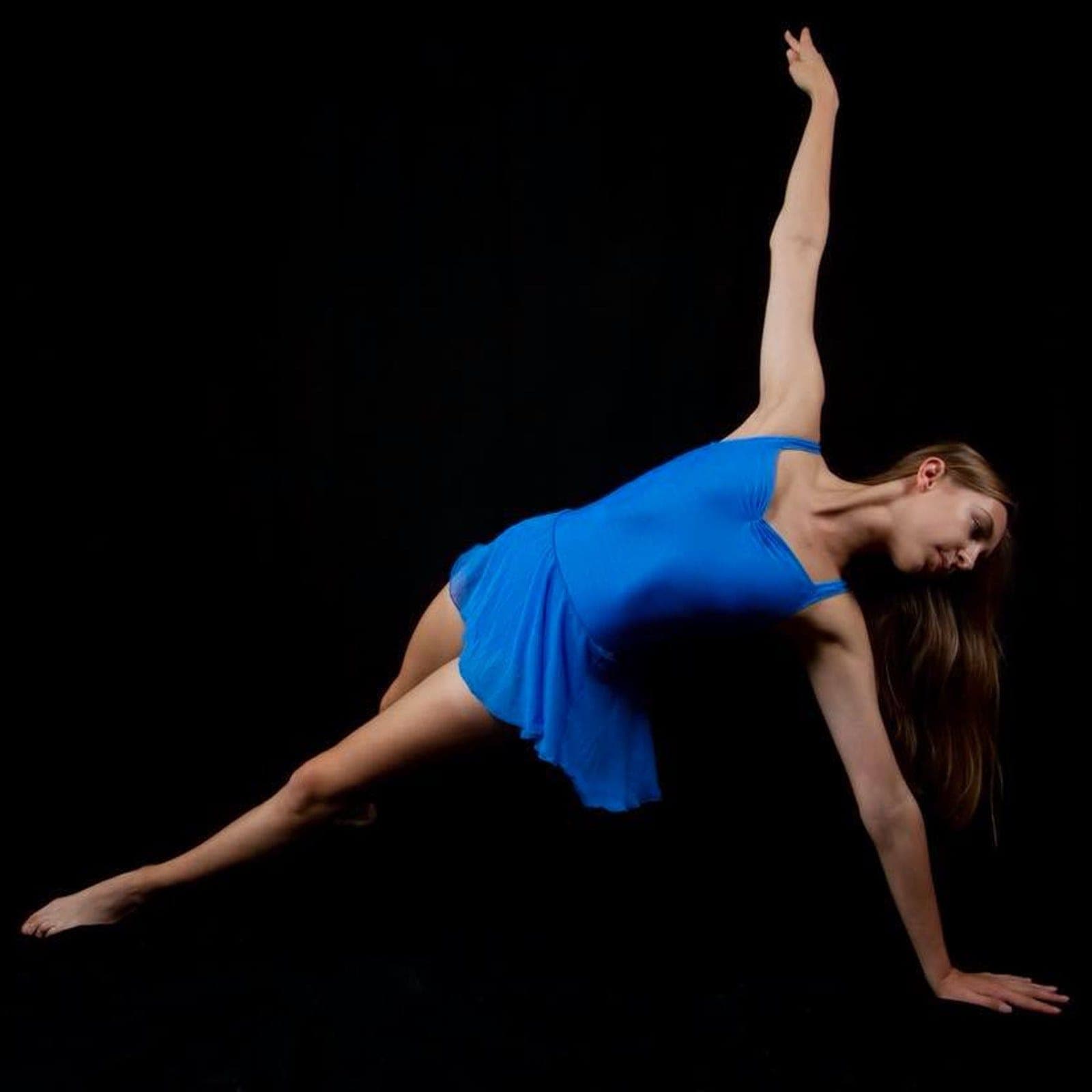 Contemporary dancer in electric blue holding a floor pose
