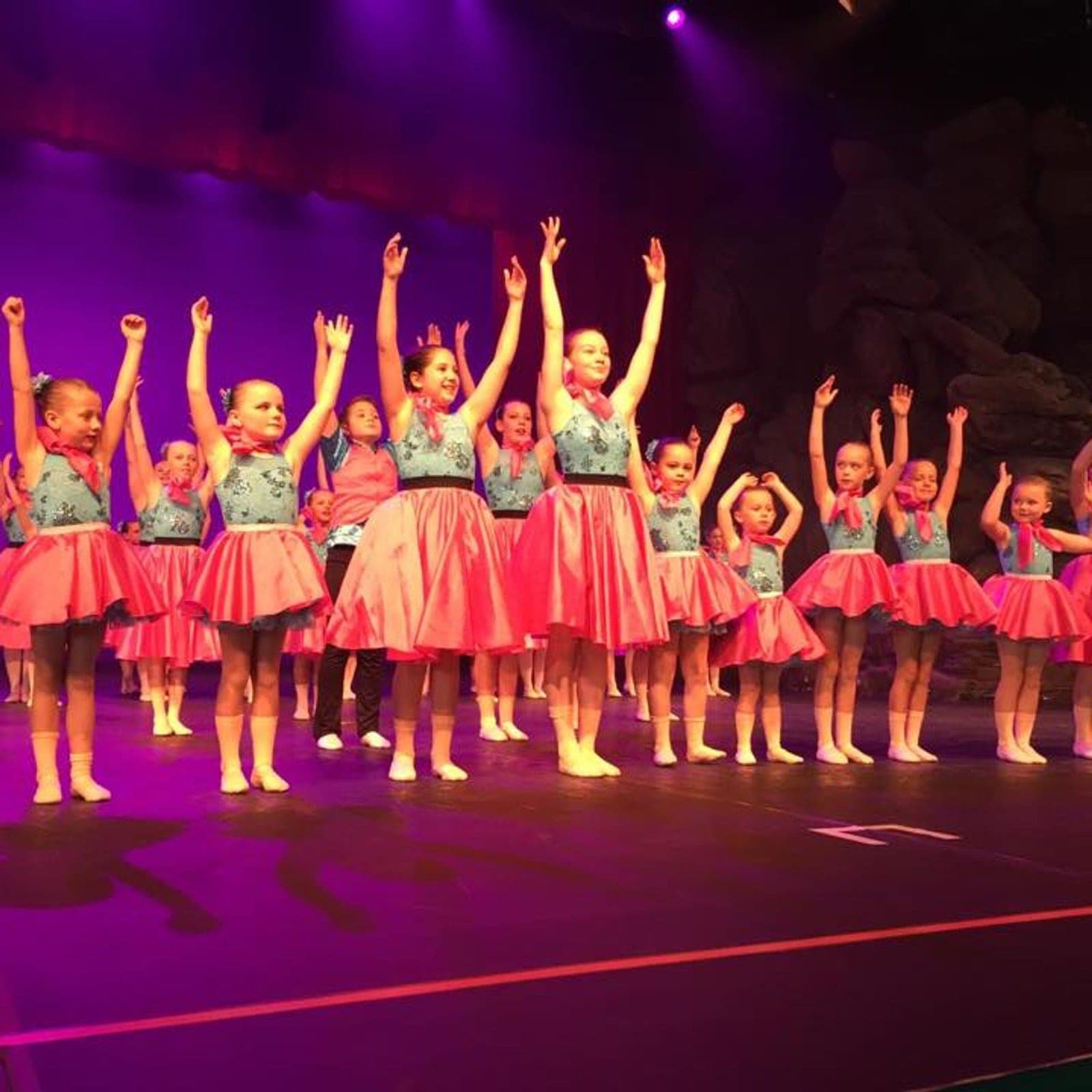 Young dancers in pink skirts on stage