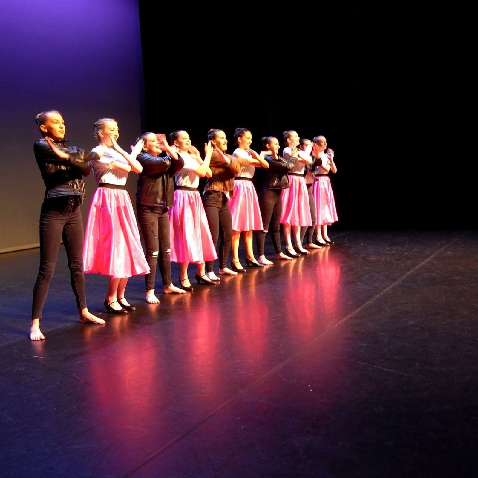 Musical theatre dancers in a high-energy stage number